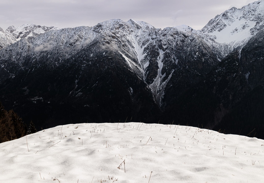 Schneebedeckter Hang und Gailtaler Alpen