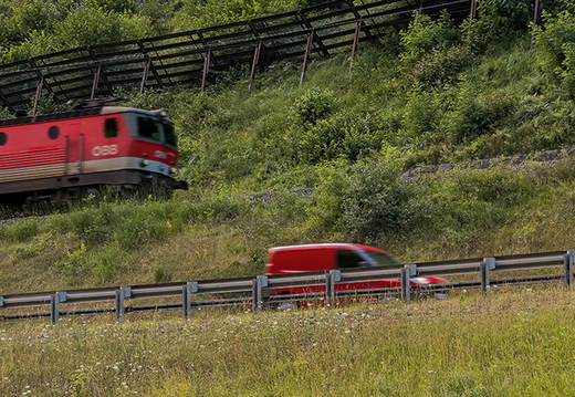 Rote Fahrzeuge in grüner Landschaft